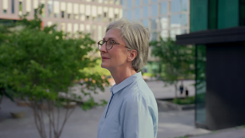 Female business portrait middle-aged thoughtful businesswoman old lady pensive looking away smiling inspired mature woman enjoy city outdoors happy adult entrepreneur office employer CEO in downtown Royalty-Free Stock Footage #1110123451