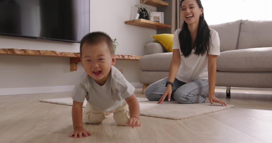 Mother and son. Cinematic Chinese, Japanese, Korean, Asian. Baby crawls away from his mother on all fours. Heartwarming moments mother and child experience together, emotions of love, tenderness Royalty-Free Stock Footage #1110123925