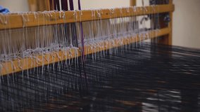 old wooden loom with strings of cloth