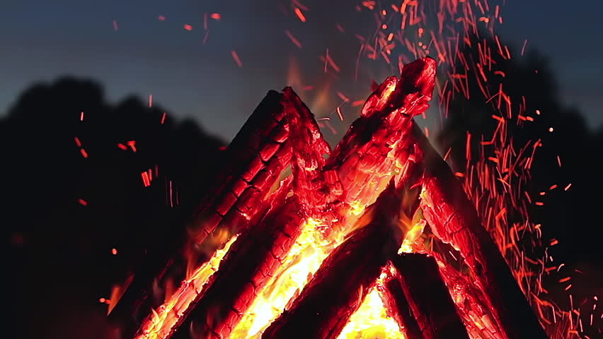Big Burning Campfire in Early Morning or Evening against the Blue Sky. Wood on Fire. Flying Sparks. Travel and Tourism Concept. Giant Flaming Bonfire at Summer - Static Shot, Slow Motion Royalty-Free Stock Footage #1110124401