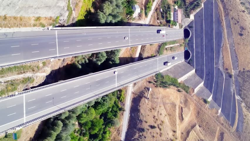 Aerial view of a amazing green landscape highway that runs through the mountains
