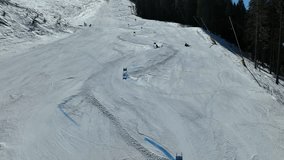 Skiing. Aerial drone view of skier skiing downhill on snowy mountain slopes. A person who skis and competes on the slopes. Outdoor winter sports video