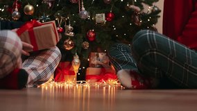 family couple exchange gifts box sitting under decorated Christmas tree baubles balls and blinking golden lights garland. tradition boxing day next morning after Christmas night concept - Powered by Shutterstock - Get 15% off with code: PIKWIZARD15