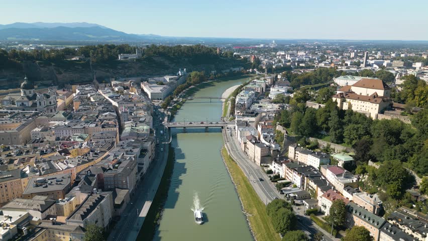 Drone Flies Backward Above Salzach River in Salzburg, Austria. Beautiful Summer Day