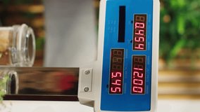 Vertical video Close up of electronic scale in zero waste supermarket with low carbon dioxide emissions. Panning shot of weighing machine in local grocery store used for bulk products, fruits and