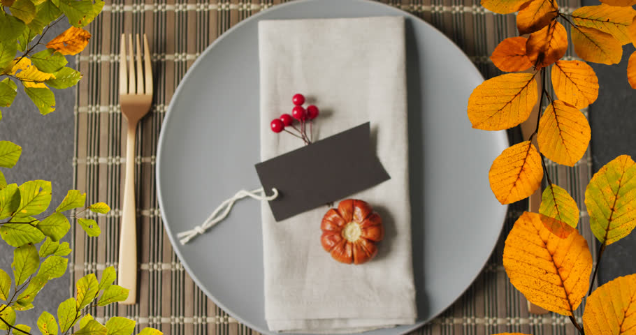Animation of autumn leaves over thanksgiving dinner place setting background. Thanksgiving, american tradition and celebration concept digitally generated video. Royalty-Free Stock Footage #1110135875