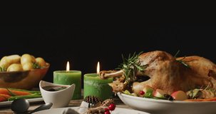 Animation of happy thanksgiving text and dinner and candles on black background. Thanksgiving, american tradition and celebration concept digitally generated video.