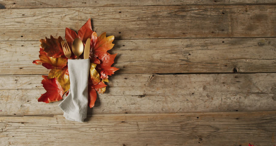 Animation of autumn leaves over thanksgiving dinner place setting background. Thanksgiving, american tradition and celebration concept digitally generated video. Royalty-Free Stock Footage #1110137869