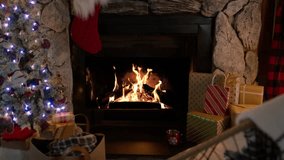 Cozy fireplace at home, cinematic Christmas decorated interior. Winter season indoor environment with Christmas tree light garland and warm golden fire flames burning in slow motion - Powered by Shutterstock - Get 15% off with code: PIKWIZARD15
