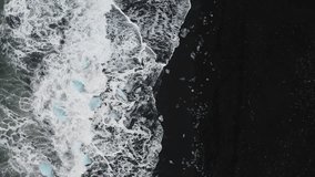 Stunning drone shot of surf with ice rocks at Diamond Beach in Iceland