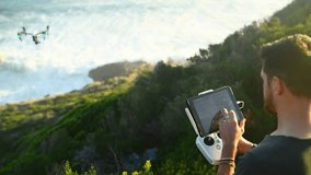 Remote control, drone and man with photography on beach filming nature, water or landscape. Videography, photographer and test technology in flight for aerial recording of ocean at sunset or sunrise