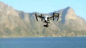 Drone, photography and flight of technology at the beach filming sea landscape with water and mountain. Remote control, device and recording videography surveillance of ocean, nature and blue sky