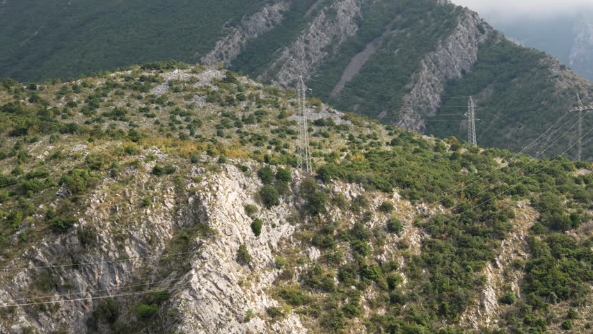A power line in the mountains. Electrification of mountainous terrain. Civilization in inaccessible areas. . High quality 4k footage