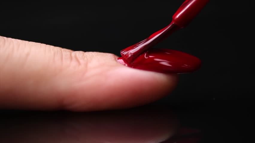 Applying Nail polish, red shellac UV gel, varnish, manicure process concept. Manicure salon. Black background. Application of nail polish close up Royalty-Free Stock Footage #1110152819