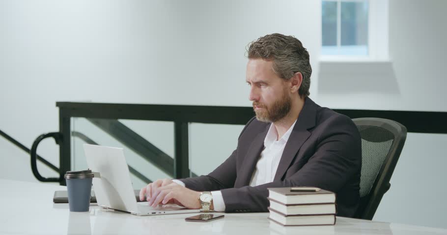 Office worker with laptop at office. Ofice employee remote working in modern office. Businessman have on line meeting. Business man using computer in office. Modern offices workplace.