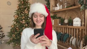 a happy girl talks on the phone, makes a video call, congratulates friends on Christmas and New year
