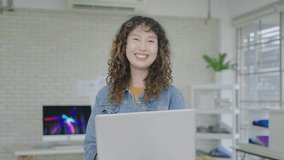 Modern Office: Portrait of asian business woman have confident and fashionable , Holding Laptop Computer, Looking at Camera, Smiling Charmingly. Working on Design, Data Analysis, Plan Strategy - Powered by Shutterstock - Get 15% off with code: PIKWIZARD15
