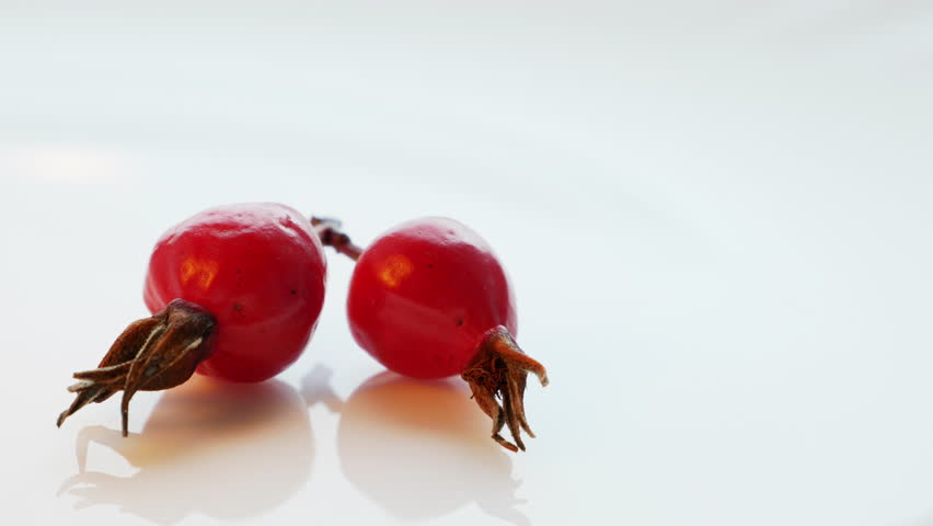 The fruits of wild rose or rose hips are the richest in vitamin C. Ethnoscience. Alternative medicine. Chinese traditional medicine. Self-medication. Smooth rotation in white dish Royalty-Free Stock Footage #1110172515