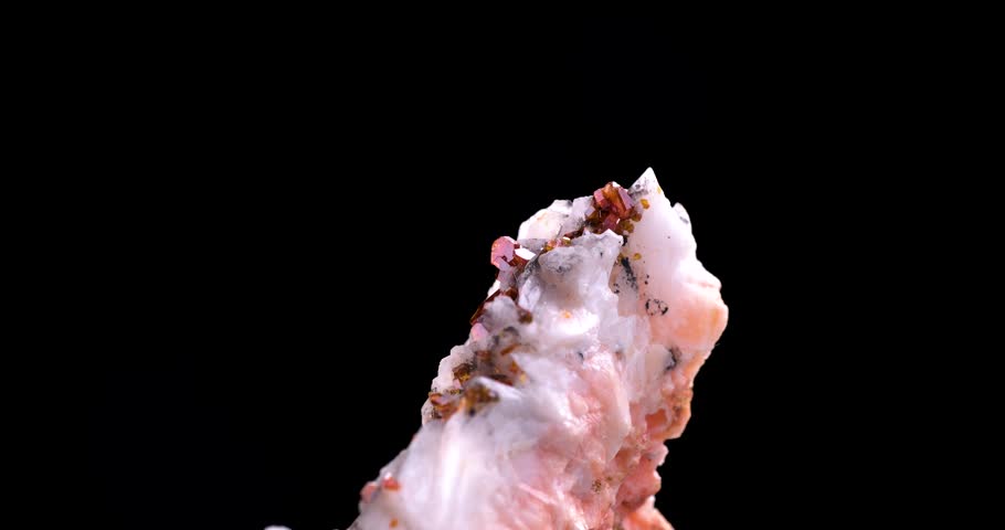 orange vanadinite on baryte rotating 360° in 4k isolated on black background. macro detail close-up rough raw unpolished semi-precious gemstone.
