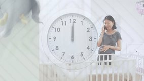 Clock with fast moving hands over happy pregnant asian woman by cot talking on phone. Pregnancy, self care, time, communication, expectancy, motherhood and domestic life digitally generated video.