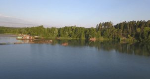 4K summer sunrise aerial video of green pine trees forest and calm lake in Europe