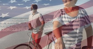 Animation of flag of usa over happy senior biracial couple with bikes on beach. American patriotism, nationality, summer and diversity concept digitally generated video.