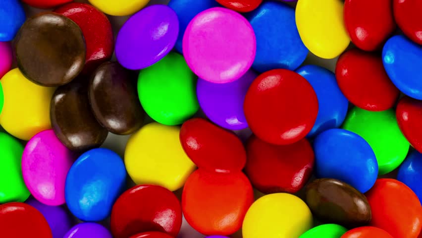Rotating Colorful Lentilky Dragee Candy in Chocolate Coating, colorful candy background. Royalty-Free Stock Footage #1110180831