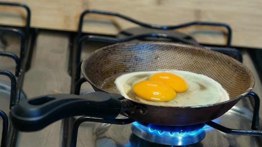 Slow zoom in. Frying an egg with double yolks. Fried eggs in a skillet. Food in a pot. Double fried eggs. Making fried eggs in a frying pan.Dinner time. Frying eggs, close-up shot. Frying food in oil Royalty-Free Stock Footage #1110180905