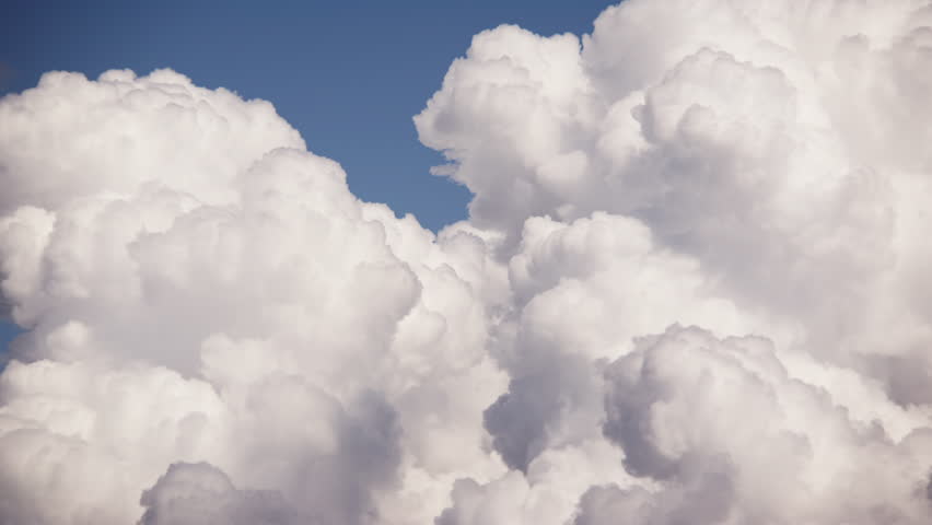 The clouds, resembling soft pillows, gracefully billowing across the vast azure sky Royalty-Free Stock Footage #1110185731