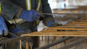 Construction works with metal rods as workers use a rebar screed, a tool for ensuring precision and alignment on the construction site.