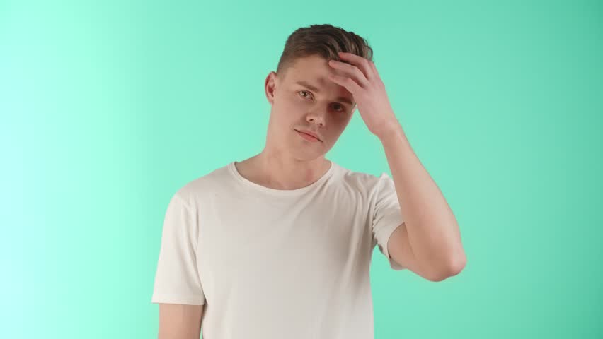 A charming young man in positive emotions demonstrates an attractive, well-groomed appearance and care about himself. A handsome glad guy shows self-love and confidence. Emotions of joy and