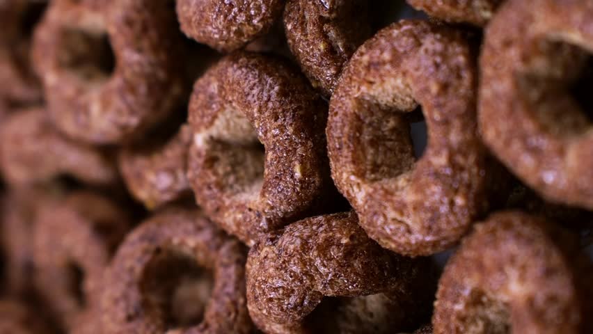 Vertical video format, Brown chocolate breakfast rings cereal falling down close up Royalty-Free Stock Footage #1110192525