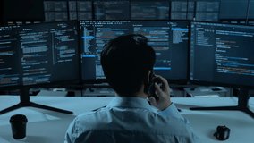 Back View Of Asian Man Developer Talking On Mobile Phone While Write Code With Multiple Computer Screens In The Office - Powered by Shutterstock - Get 15% off with code: PIKWIZARD15