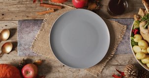 Animation of happy thanksgiving text and place setting over wooden background. Thanksgiving, american tradition and celebration concept digitally generated video.