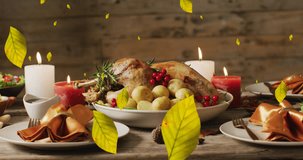Animation of autumn leaves over thanksgiving dinner background. Thanksgiving, american tradition and celebration concept digitally generated video.