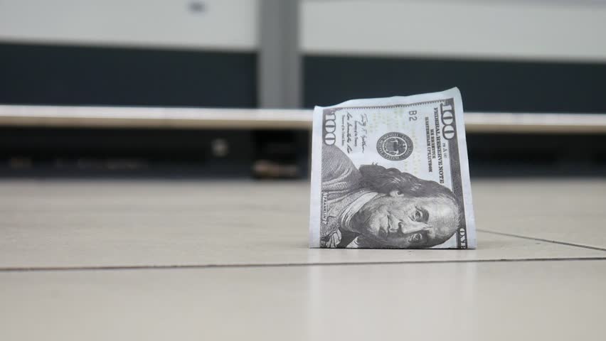 A lost hundred dollar bill lying on the floor and a man with a shopping trolley finds it