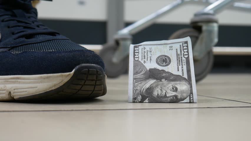 A lost hundred dollar bill lying on the floor and a man with a shopping trolley finds it