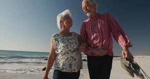 Animation of social media text and icons over senior caucasian couple on beach. Global social media, digital interface, computing and data processing concept digitally generated video.