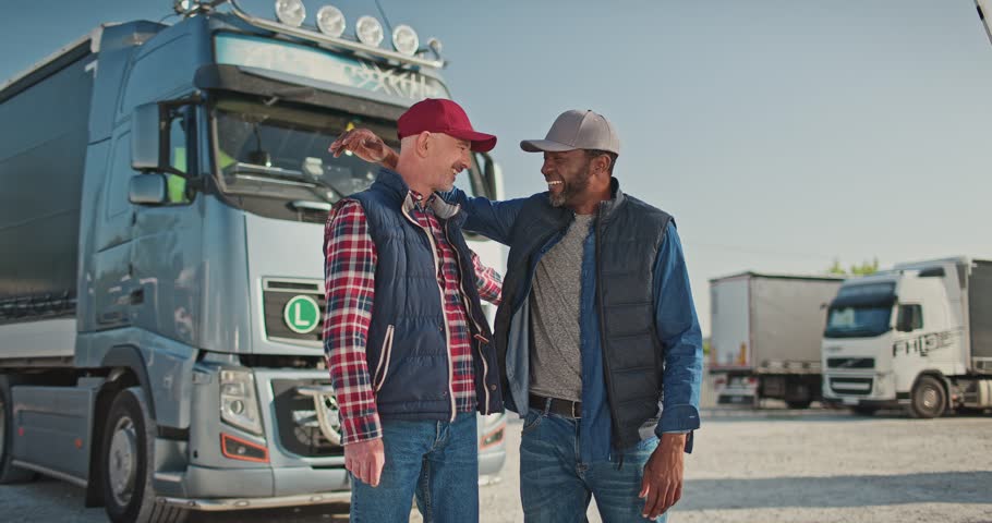 Portrait of happy professional workers, truck drivers. Two multicultural male colleagues looking at camera and smiling. Confident lorry drivers with vehicle in parking lot. Truck car travels Royalty-Free Stock Footage #1110205655