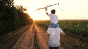 Father rides little son with kite on shoulders running along road at twilight - Powered by Shutterstock - Get 15% off with code: PIKWIZARD15