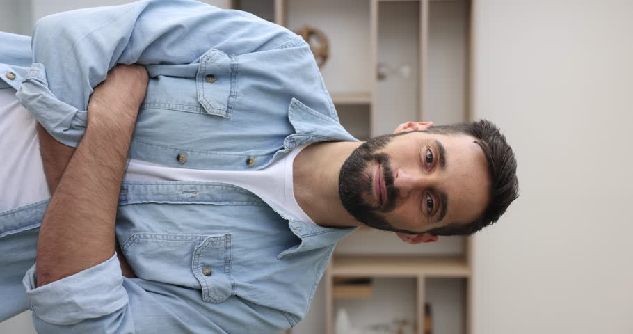 Happy bearded millennial Hispanic businessman, company male employee or freelancer posing standing alone indoor. Professional occupation person at workplace, promoted or hired worker vertical portrait Royalty-Free Stock Footage #1110213565