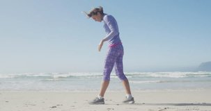 Animation of social media data processing over caucasian woman in sports clothes on beach. Global fitness, networks, computing, digital interface and data processing concept digitally generated video.