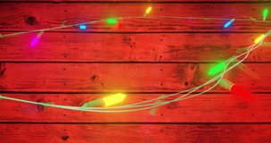 Animation of flickering fairy lights with copy space on wooden background. Christmas, tradition and celebration concept digitally generated video.