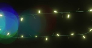 Animation of flickering fairy lights over spots of light background. Christmas, tradition and celebration concept digitally generated video.