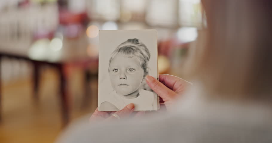 Memory, photo and zoom on hands of senior woman with nostalgia, past or history at home. Closeup, pictures and elderly female person remember with photograph collection in a house, lonely or alone