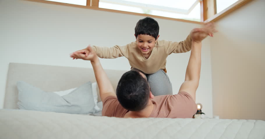 Man, boy and child on bed with plane, fantasy and childhood game for freedom, happiness and bond in home. Family, father and son in bedroom with flying, lifting and smile for love, care and support