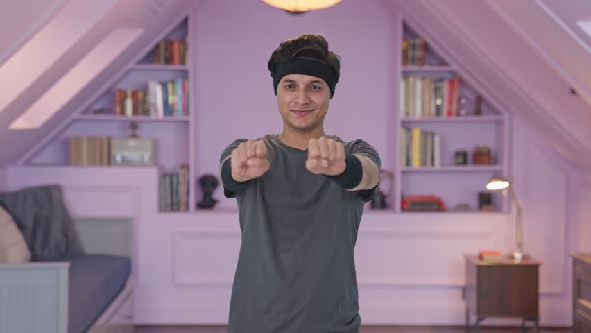 Happy Indian man doing wrist rotation exercise