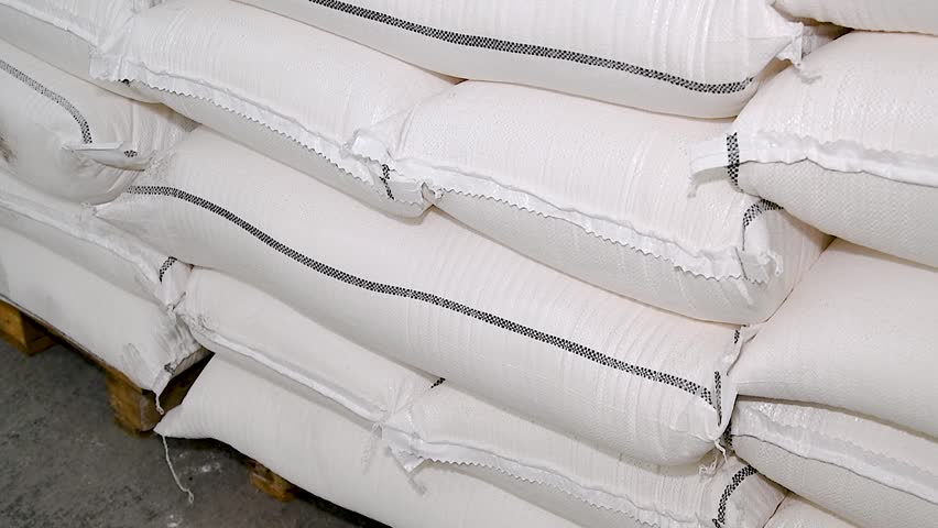 Food warehouse. Bags of rice, sugar, flour and other products. Warehouse filled with white heavy bags that lie on pallets Royalty-Free Stock Footage #1110224585