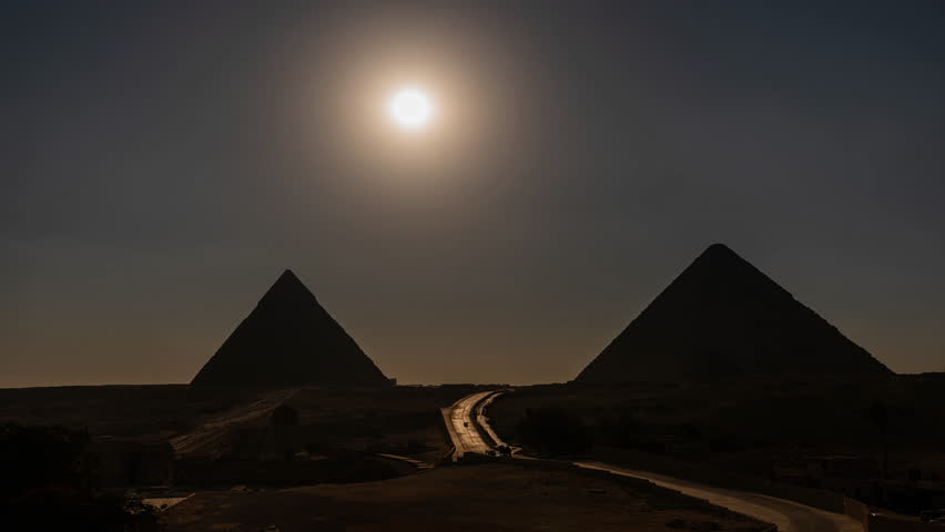 The sun is setting behind the two largest pyramids (Khafre Khufu) and in Giza close to Cairo in Egypt
