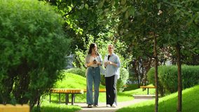 Smiling female friends talking while walking outdoors. Two young women having conversation in the park, pretty girls chatting and gossiping. Business women share ideas during work break - Powered by Shutterstock - Get 15% off with code: PIKWIZARD15